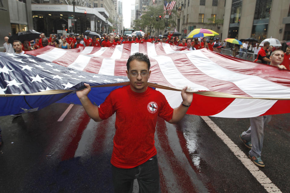 File - Local 361 iron worker Robert Farula marches up Fifth Ave. carrying an American flag during the Labor Day parade on Sept. 8, 2012 in New York. Labor Day, 2023, is right around the corner. And while many may associate the holiday with major retail sales and end-of summer barbecues, Labor Day's roots in worker-driven organizing feel especially significant this year. (AP Photo/Mary Altaffer, File)