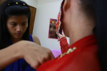 Htet Htet Htun, a Miss Myanmar World finalist, looks at a mirror before her rehearsal at a studio in Yangon August 12, 2014.REUTERS/Soe Zeya Tun