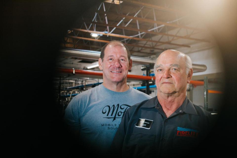 Two men standing in a record pressing plant