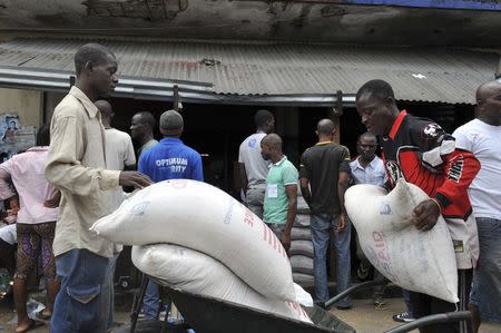 Residents of West Point neighbourhood, which has been quarantined following an outbreak of Ebola, receive food rations from the United Nations World Food Programme (WFP) in Monrovia August 28, 2014. REUTERS/2Tango