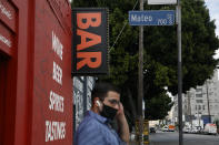 Un hombre espera el autobús cerca de un bar cerrado por la pandemia del coronavirus en Los Ángele,sel lunes 29 de junio de 2020. (AP Foto/Jae C. Hong)