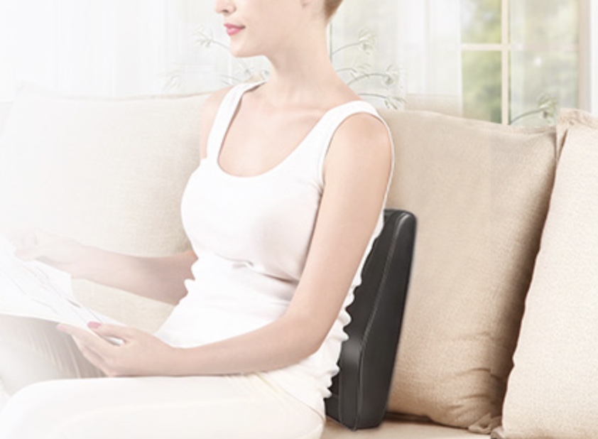 person using a back massager on couch