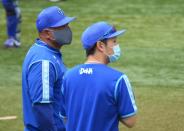 Yokohama DeNA BayStars manager Alex Ramirez wearing a protective face mask talks with a coach amid the coronavirus disease (COVID-19) outbreak, in Yokohama, Japan