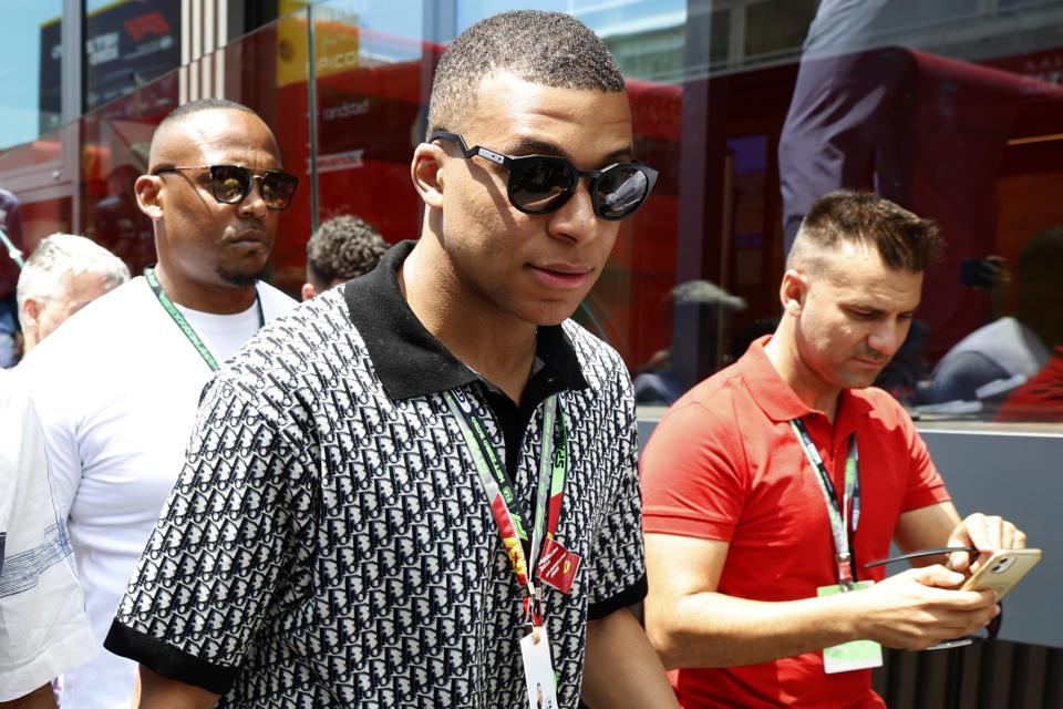 French footballer Kylian Mbappe walks through the paddock before the start of the Spanish Formula One Grand Prix at the Barcelona Catalunya racetrack in Montmelo, Spain, Sunday, June 4, 2023. (AP Photo/Joan Monfort)