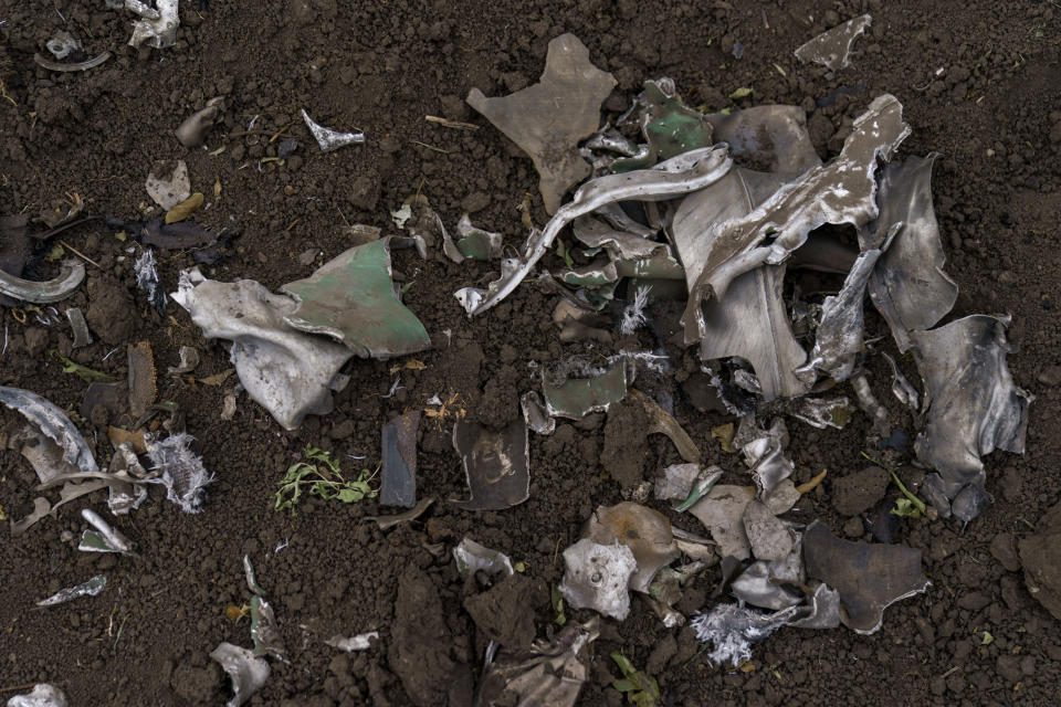 Shrapnel from a Russian rocket attack a day before sits next to the impact crater, Saturday, Aug. 13, 2022, in Kramatorsk, Donetsk region, eastern Ukraine. The strike killed three people and wounded 13 others, according to the mayor. The attack came less than a day after 11 other rockets were fired at the city, one of the two main Ukrainian-held ones in Donetsk province, the focus of an ongoing Russian offensive to capture eastern Ukraine's Donbas region. (AP Photo/David Goldman)