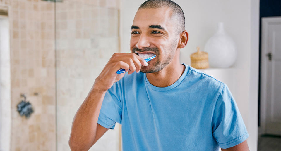 Man brushing teeth to represent oral health. (Getty Images)
