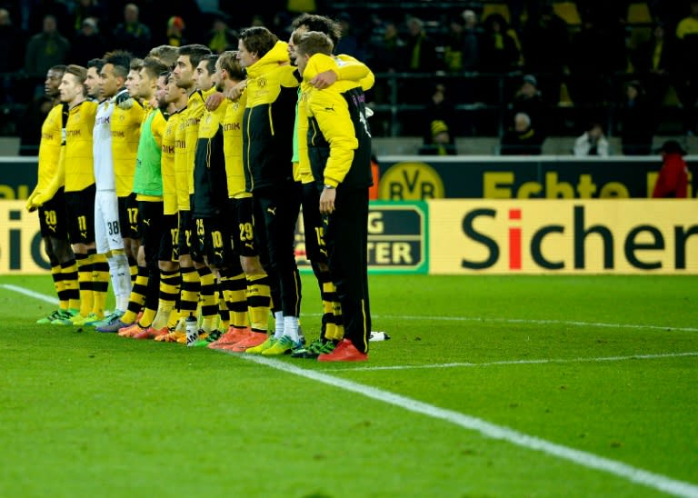 Dormund's players line up to show their respects after the death of a fan during the German first division Bundesliga football match Borussia Dortmund v 1 FSV Mainz 05 in Dortmund, on March 13, 2016