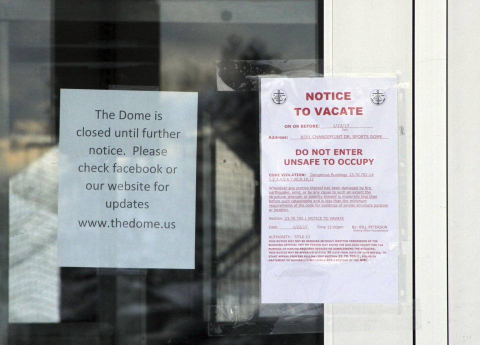 Signs are posted on the door of The Dome, a 180,000-square foot indoor sports facility in Anchorage, Alaska, on Tuesday, Jan. 24, 2017, three days after the thin, flexible plastic roof collapsed in the midst of a snowstorm. The facility is among others, including an old lumber mill in Oregon, the main grocery store in a small Idaho town, and a conference center in Colorado that have collapsed under the accumulated weight of snow this winter. (AP Photo/Mark Thiessen)