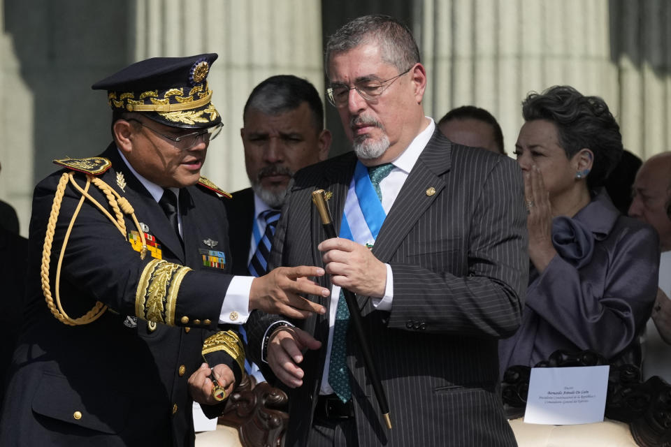 El general del Ejército Henry Sáenz entrega el bastón de mando al nuevo presidente Bernardo Arévalo en un acto oficial en la plaza de la Constitución en Ciudad de Guatemala, el lunes 15 de enero de 2024, la mañana posterior a su investidura. (AP Foto/Moisés Castillo)