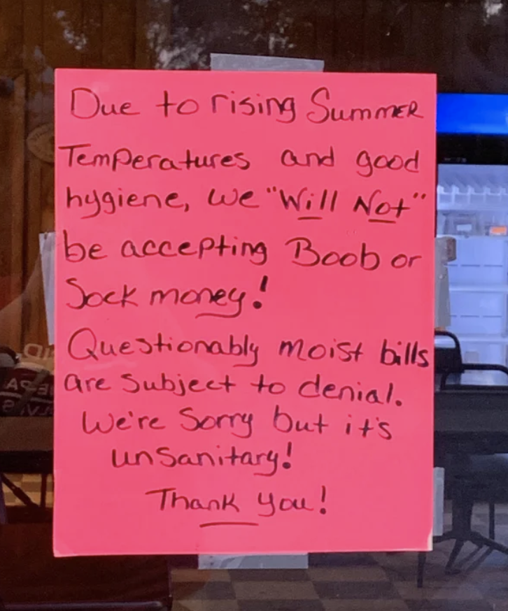 The sign says "due to rising summer temperatures and good hygiene, we will not be accepting boob or sock money; questionably moist bills are subject to denial"