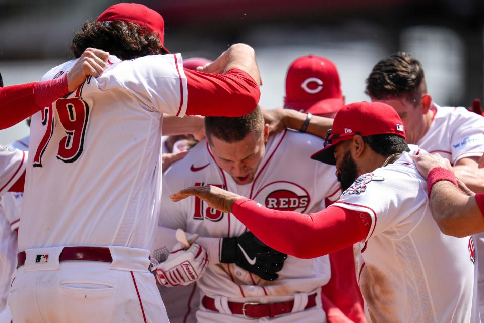 Cincinnati Reds third baseman Nick Senzel is mobbed by his teammates after hitting a walk-off two-run home run against the Texas Rangers. It's the first walk-off homer of Senzel's career.