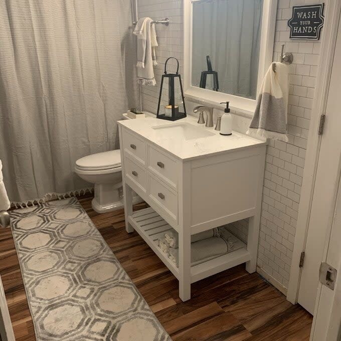 a reviewer photo of the white subway tile backsplash in a bathroom