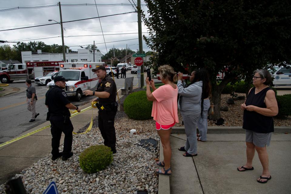 Law enforcement personnel hang yellow tape to keep onlookers back from the corner of Weinbach Avenue and Vogel Road after a house explosion at 1010 N. Weinbach Avenue in Evansville Wednesday afternoon, Aug. 10, 2022.