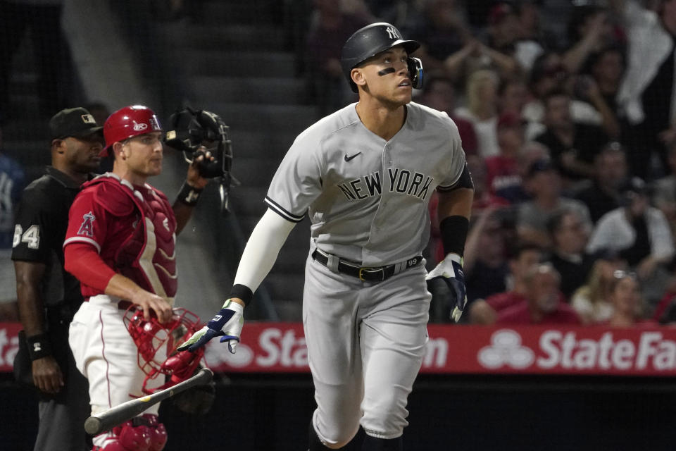 New York Yankees' Aaron Judge, right, drops his bat after hitting a three-run home run, next to Los Angeles Angels catcher Max Stassi and home plate umpire Alan Porter during the fourth inning of a baseball game Tuesday, Aug. 30, 2022, in Anaheim, Calif. (AP Photo/Mark J. Terrill)