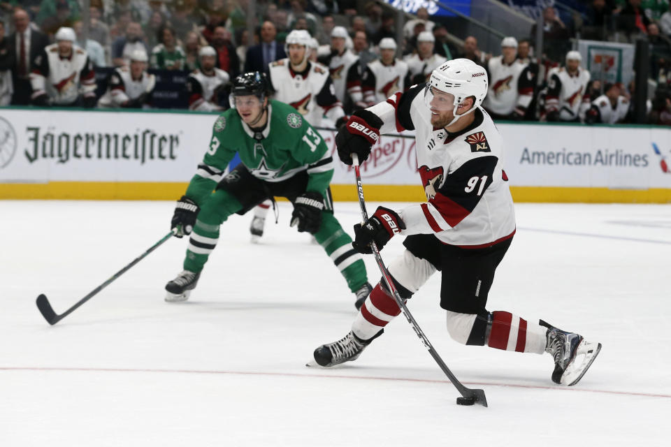 Arizona Coyotes left wing Taylor Hall (91) shoots for a goal in front of Dallas Stars center Mattias Janmark (13) during the second period of an NHL hockey game in Dallas, Wednesday, Feb. 19, 2019. (AP Photo/Michael Ainsworth)