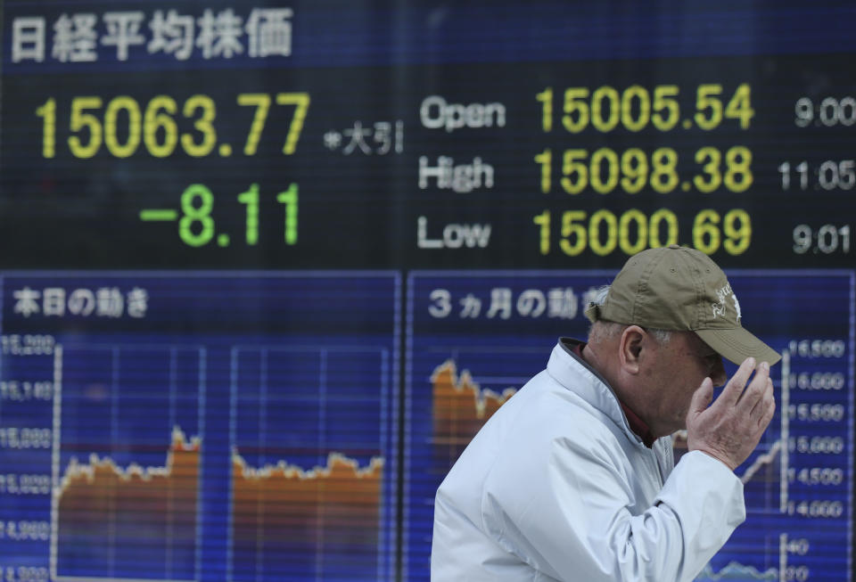 A man walks by an electronic stock board of a securities firm showing Tokyo's Nikkei 225 that slipped 8.11 points, or 0.05 percent to close at 15,063.77 in Tokyo, April 4, 2014. Asian stock markets were little changed Friday after the European Central Bank refrained from further easing of monetary policy and investors looked to the upcoming U.S. jobs report for a new trading cue. (AP Photo/Eugene Hoshiko)