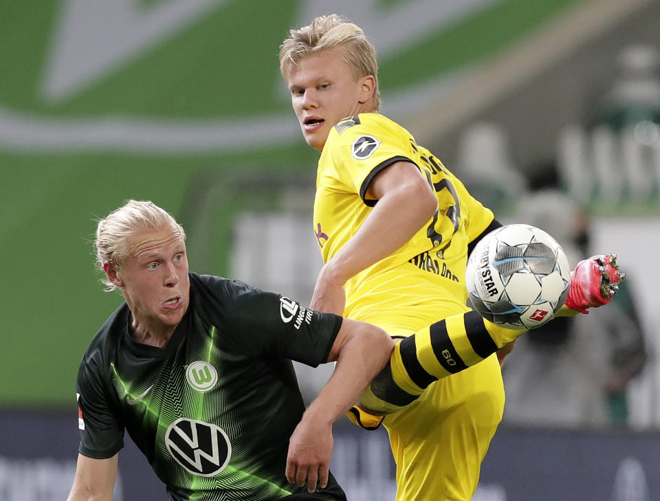 Xaver Schlager (izquierda) del Wolfsburg pugna el balón con Erling Haaland del Borussia Dortmund en el partido de la Bundesliga, el sábado 23 de mayo de 2020. (AP Foto/Michael Sohn, Pool)