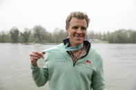 Cambridge's James Cracknell celebrates with his medal after the Men's Boat Race on the River Thames, London, Sunday, April 7, 2019. (Adam Davy/PA via AP)