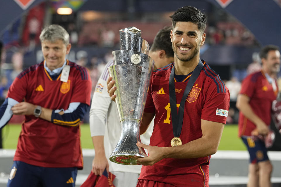 Marco Asensio celebra con el trofeo después de ganar la final de la Liga de Naciones en partido entre Croacia y España, en el estadio De Kuip, en Rotterdam, Holanda, el domingo 18 de junio de 2023. Asensio llega al PSG con un contrato por tres años hasta junio de 2026, dijo el equipo francés. (AP Foto/Martin Meissner)