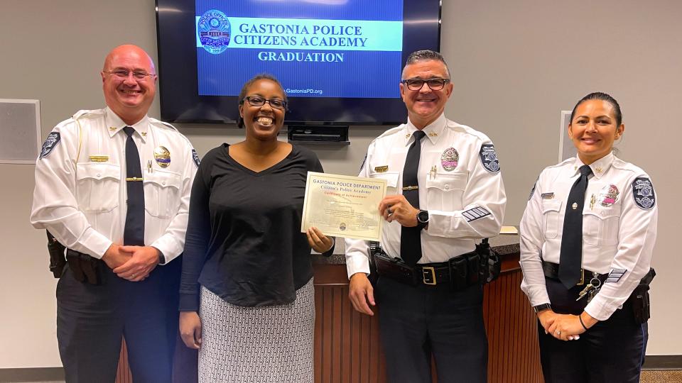 Crystal Byrd Farmer receives a certificate for graduating the Gastonia Police Academy from Chief Travis Brittain as Assistant Chiefs Trent Conard and Nancy Brogdon watch on.