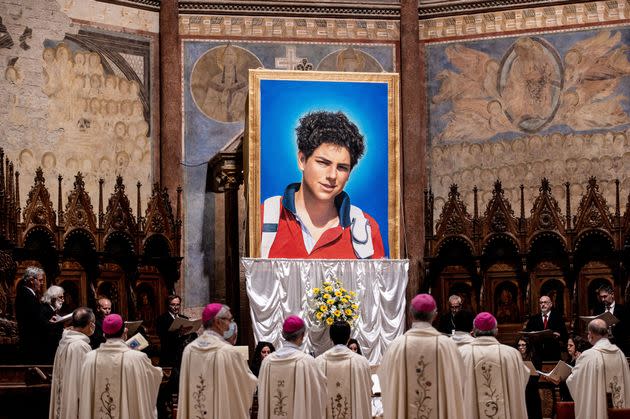 A tapestry featuring a portrait of Carlo Acutis hangs at the St. Francis Basilica in Assisi, Italy, during a beatification ceremony in October 2020. He is set to become the first saint born in the millennial generation.