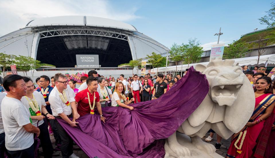 Senior Parliamentary Secretary for the Ministry of Culture, Community and Youth Baey Yam Keng (in red shirt) unveiling one of two Merdeka Lions in front of the National Stadium during the launch of the Kallang sports, arts and heritage trail. (PHOTO: Singapore Sports Hub)