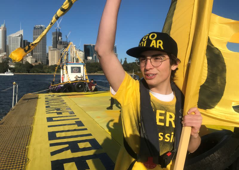 Ambrose Hayes, a 15-year-old climate change activist, rides on a barge during an event as part of the Fund Our Future Not Gas climate rally in Sydney Harbour