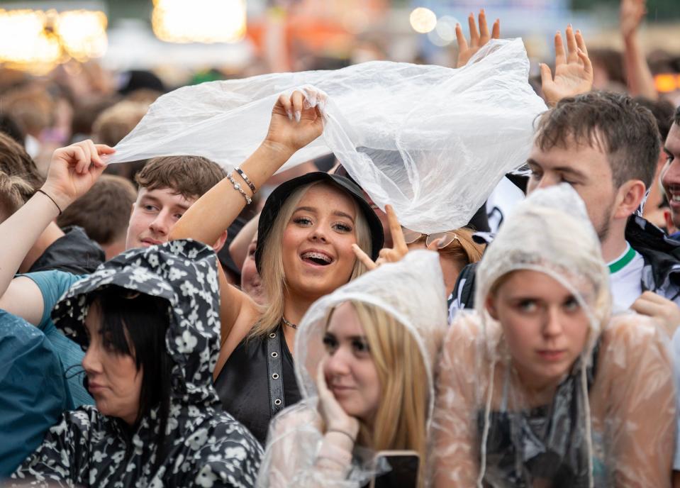 Music fans in plastic rain ponchos