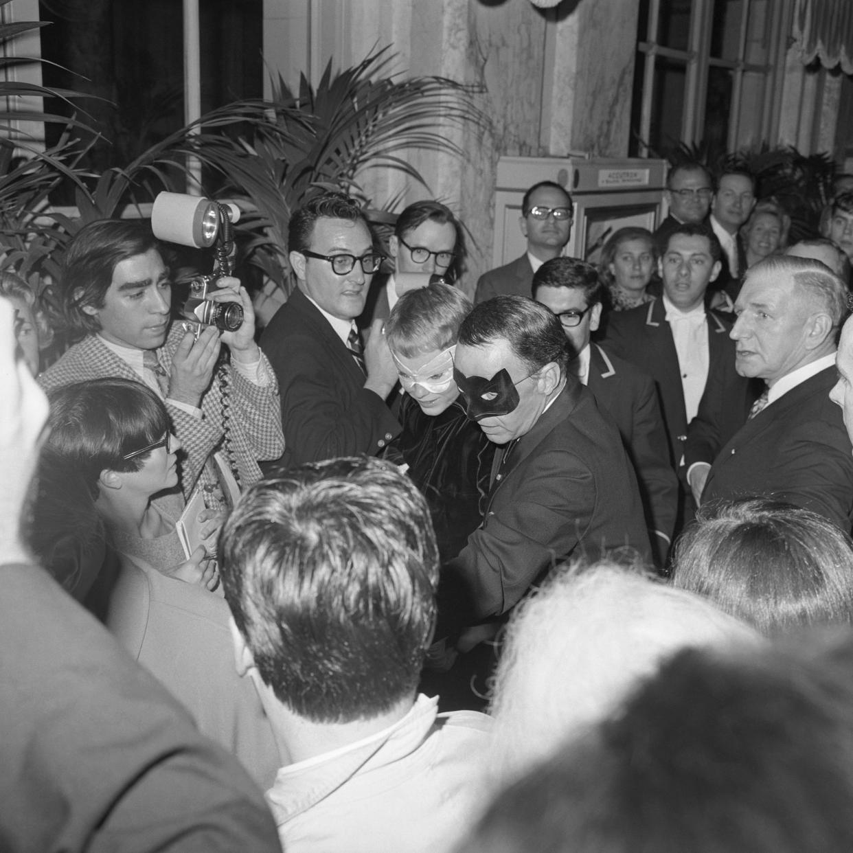 Reporters swarm Frank Sinatra and Mia Farrow as they arrive at Truman Capote’s Black and White Ball.<span class="copyright">Bettmann Archive/Getty Images</span>
