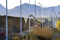 FILE - Crews construct a section of border wall in San Bernardino National Wildlife Refuge, Tuesday, Dec. 8, 2020, in Douglas, Ariz. President Biden on Wednesday ordered a "pause" on all wall construction within a week, one of 17 executive edicts issued on his first day in office, including six dealing with immigration. The order leaves projects across the border unfinished and under contract after Trump worked feverishly last year to reach 450 miles, a goal he announced was achieved eight days before leaving office. (AP Photo/Matt York)