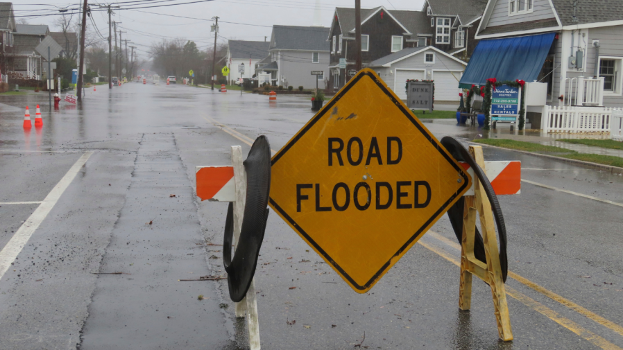 A barrier warns of flooding in Bay Head, N.J. during a storm on Monday, Dec. 18, 2023. Communities up and down the East Cast were dealing with flooding and high winds from the storm. (AP Photo/Wayne Parry)