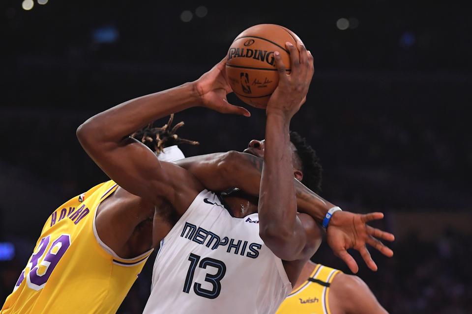 Los Angeles Lakers center Dwight Howard, left, fouls Memphis Grizzlies forward Jaren Jackson Jr. (13) in the act of shooting during the first half of an NBA basketball game Friday, Feb. 21, 2020, in Los Angeles. (AP Photo/Mark J. Terrill)