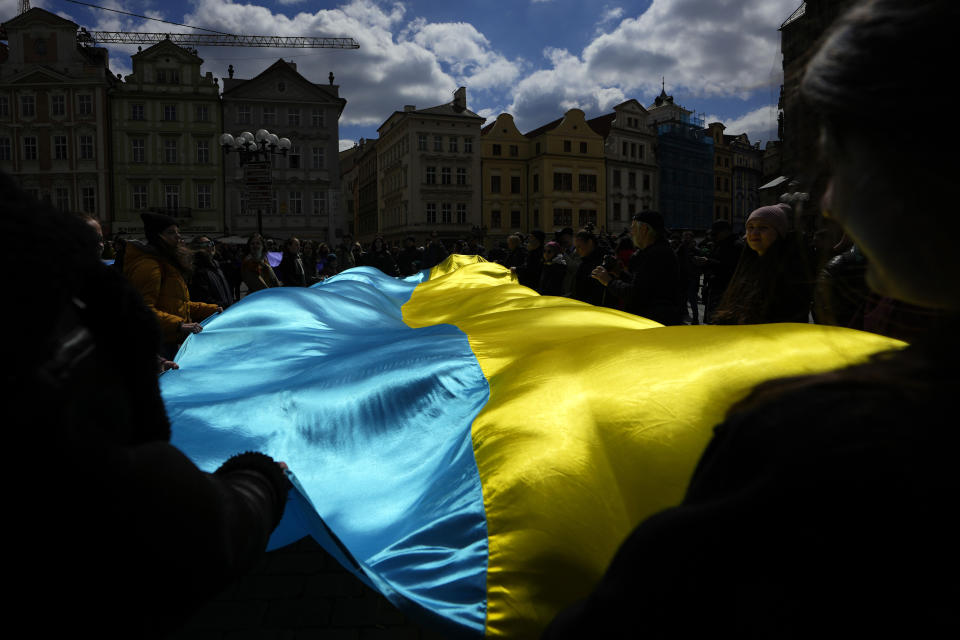 People wave a Ukrainian flag during a demonstration in support of the Estonian military strategic plan for Ukraine, at the Old Town Square in Prague, Czech Republic, April 21, 2024. (AP Photo/Petr David Josek)