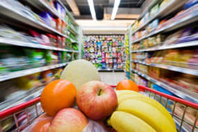 Moving shopping cart, and shot with a slow shutter from the shopper's point of view. The fruits in the shopping cart is in focus