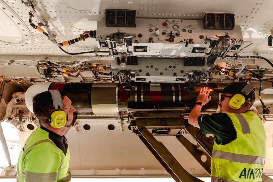 Two Air Force aviators load up a P-8A Poseidon plane with Mark 54 Lightweight Exercise Torpedos.