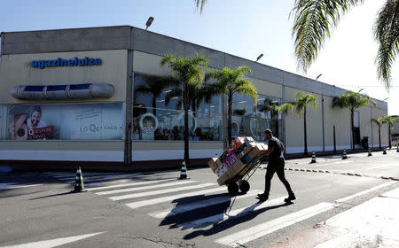 An employee carries merchandise sold via eCommerce to be delivered to customers at retail chain Magazine Luiza S.A. store in Sao Paulo, Brazil April 21, 2018. Picture taken April 21, 2018. REUTERS/Paulo Whitaker