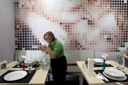 A waitress examines a plate in Izlelo, a restaurant in Szekszard, south of Budapest, September 22, 2014. REUTERS/Bernadett Szabo