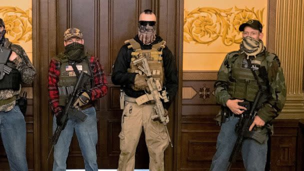 PHOTO: Joseph Morrison (3rd R), Paul Bellar (2nd R) and Pete Musico (R) who were charged for their involvement in a plot to kidnap Michigan Gov. Gretchen Whitmer, stand in the state capitol building in Lansing, Mich., April 30, 2020. (Seth Herald/Reuters, FILE)