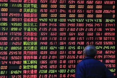 An investor looks on in front of an electronic board showing stock information at a brokerage house in Shanghai March 17, 2015. REUTERS/Aly Song