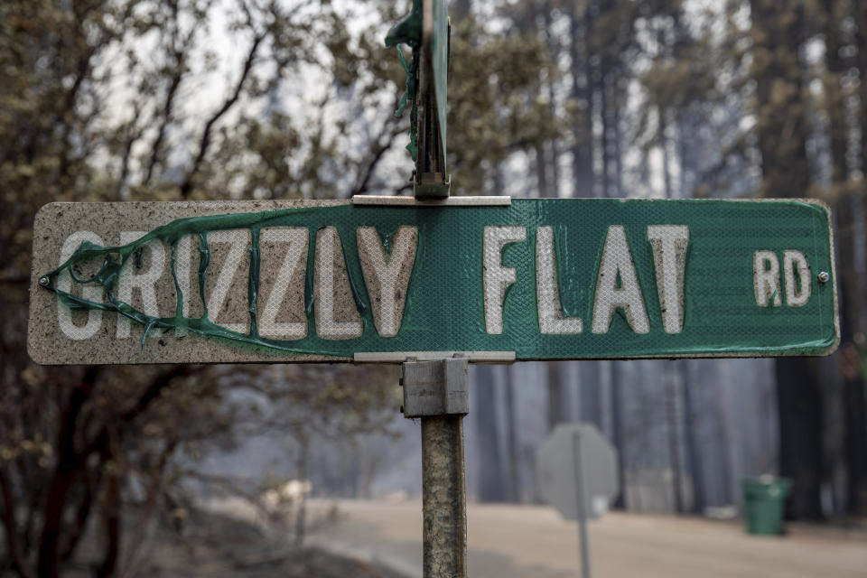 FILE - In this Tuesday, Aug. 17, 2021 file photo, a partially melted street sign stands after the Caldor Fire burned through Grizzly Flats, Calif. Last week, managers overseeing the fight against the massive wildfire scorching California's Lake Tahoe region thought they could have it contained by the start of this week. Instead, on Monday, Aug. 30, 2021, the Caldor Fire crested the Sierra Nevada, forcing the unprecedented evacuation of all 22,000 residents of South Lake Tahoe. (AP Photo/Ethan Swope, File)