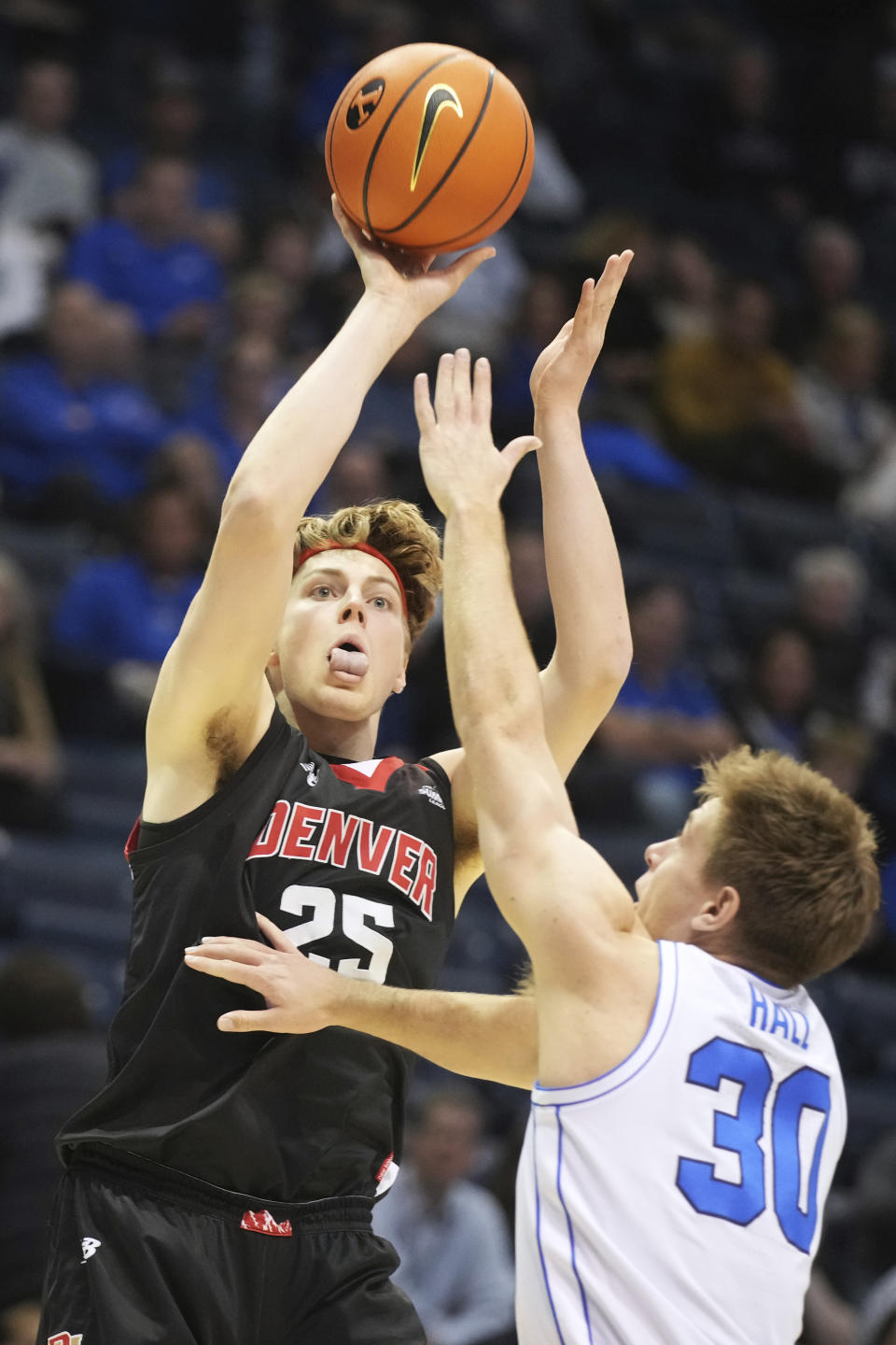 Denver forward Touko Tainamo (25) shoots over BYU guard Dallin Hall during the first half of an NCAA college basketball game Wednesday, Dec. 13, 2023, in Provo, Utah. (AP Photo/George Frey)