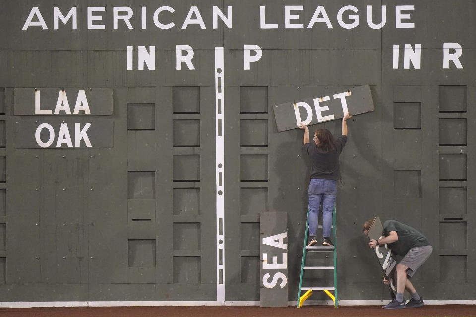 Workers clear a portion of the Green Monster scoreboard at Fenway Park following the final regular season baseball game between the Tampa Bay Rays and the Boston Red Sox, Wednesday, Oct. 5, 2022, in Boston. The Red Sox won 6-3. (AP Photo/Steven Senne)