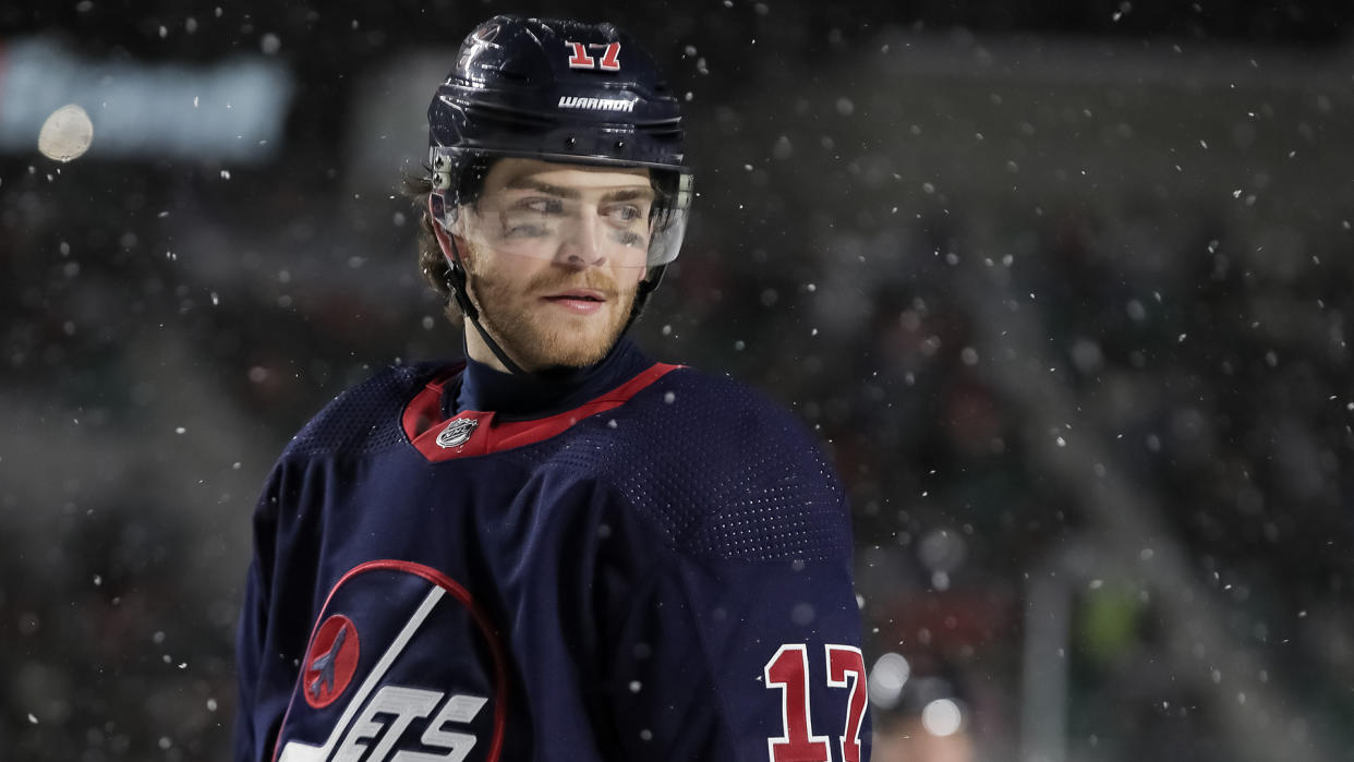 REGINA, SK - OCTOBER 26: Adam Lowry #17 of the Winnipeg Jets looks on during a stoppage in play against the Calgary Flames during the 2019 Tim Hortons NHL Heritage Classic at Mosaic Stadium on October 26, 2019 in Regina, Saskatchewan, Canada. (Photo by Andre Ringuette/NHLI via Getty Images) 