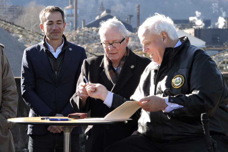 West Virginia Gov. Jim Justice, right, hands a pen used to sign House Bill 2882 to Weirton Mayor Harold "Bubba" Miller, while Form Energy CEO Mateo Jaramillo watches. HB 2882 provides $105 million toward Form Energy's plans to construct a battery manufacturing facility, Friday, Feb. 24, 2023, in Weirton, W.Va. (Craig Howell/The Weirton Daily Times via AP)