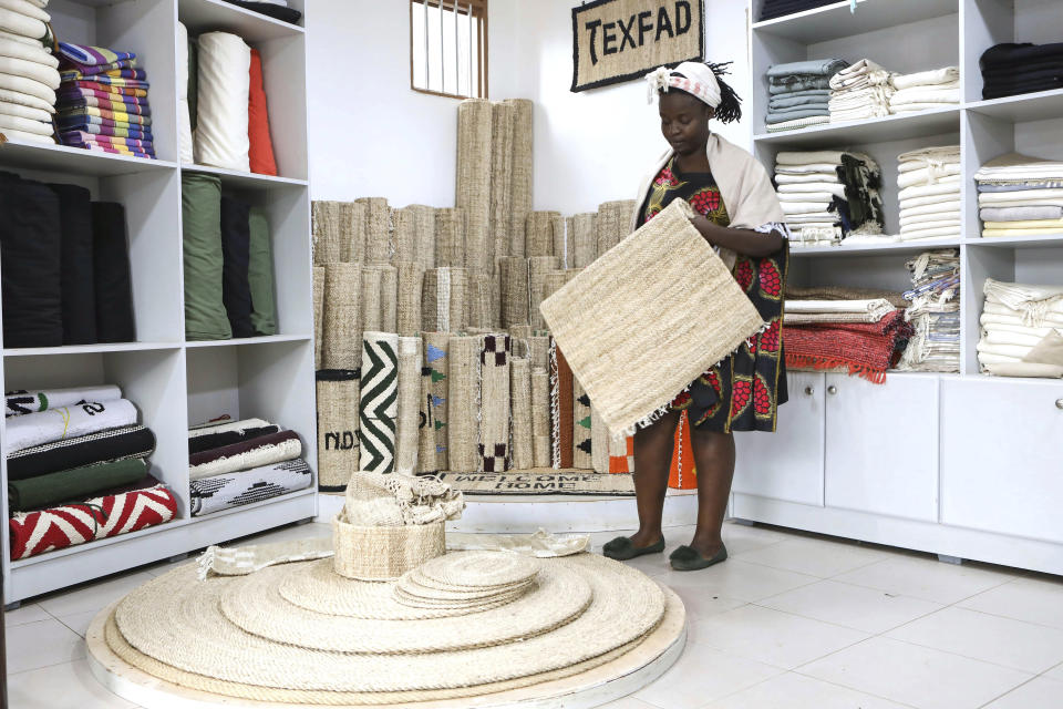 Beatrice Namawejje, marketing and sales personnel for Texfad, displays banana fiber products, at Texfad showroom in Kira, Wakiso District, Uganda, Wednesday Sept. 20, 2023. The decapitated banana plant is almost useless, an inconvenience to the farmer who must then uproot it and lay its dismembered parts as mulch. A Ugandan company is buying banana stems in a business that turns fiber into attractive handicrafts. The idea is innovative as well as sustainable in this East African country that’s literally a banana republic. (AP Photo/Hajarah Nalwadda)