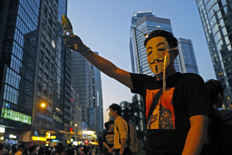 A protester wears a mask and holds up his hand as he occupied a road in Hong Kong Friday, Oct. 4, 2019. Hong Kong pro-democracy protesters marched in the city center ahead of reported plans by the city's embattled leader to deploy emergency powers to ban people from wearing masks in a bid to quash four months of anti-government demonstrations. (AP Photo/Kin Cheung)