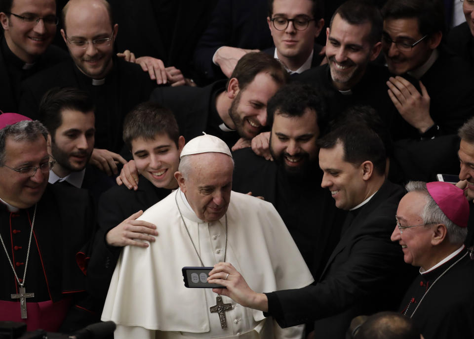 Pope Francis poses for a photo with a group of priests at the end of his weekly general audience in the Paul VI Hall at the Vatican Wednesday, Feb. 20, 2019. (AP Photo/Alessandra Tarantino)