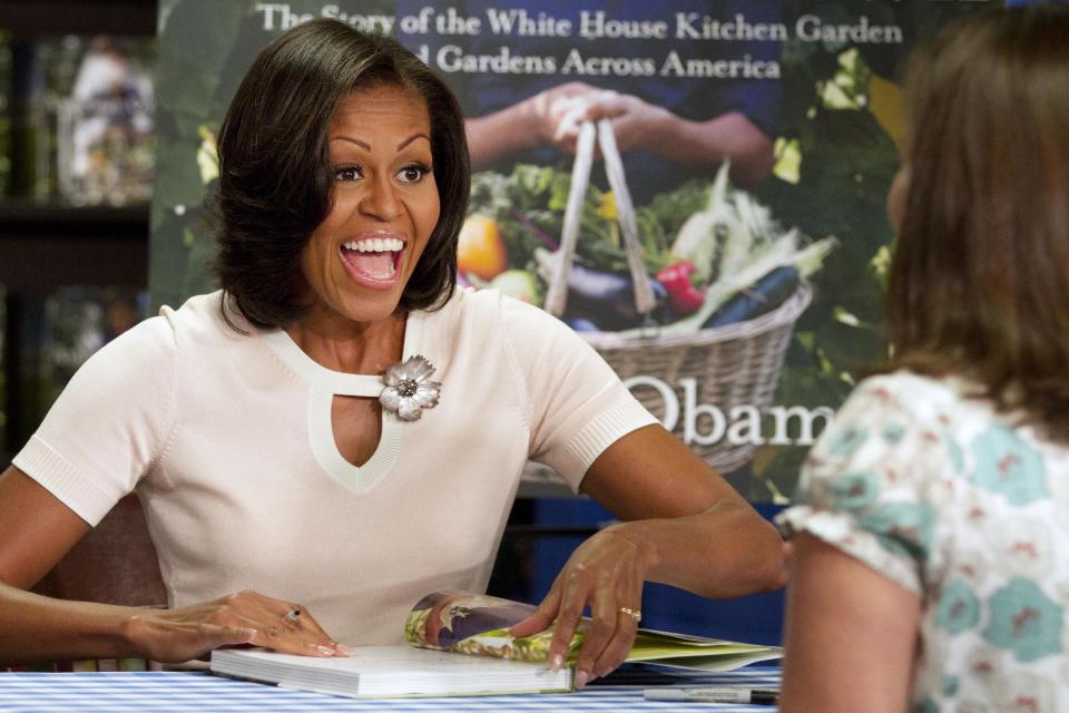 First lady Michelle Obama signs copies of her book "American Grown: The Story of the White House Kitchen Garden and Garden Across America," in Washington, Tuesday, June 12, 2012. (AP Photo/Jacquelyn Martin)
