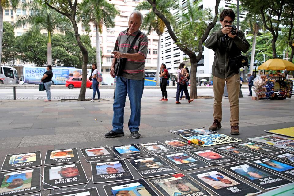 People look at photos on the ground.