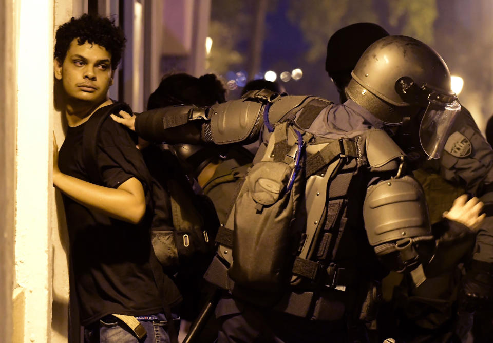 Police arrest a demonstrator during clashes in San Juan, Puerto Rico, Wednesday, July 17, 2019. Thousands of people marched to the governor's residence in San Juan on Wednesday chanting demands for Gov. Ricardo Rossello to resign after the leak of online chats that show him making misogynistic slurs and mocking his constituents. (AP Photo/Carlos Giusti)